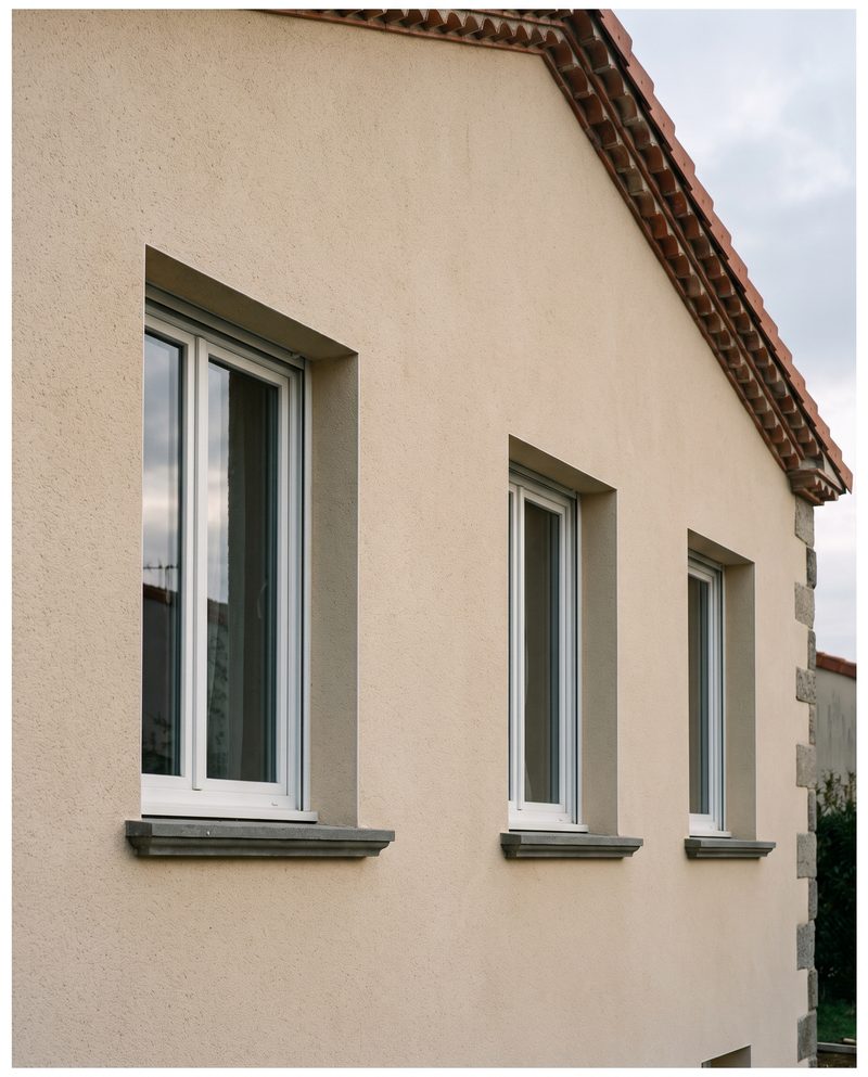 Façade isolée par l’extérieur, enduit de finition beige et appuis de fenêtre neufs